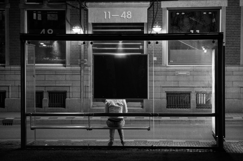 Femme qui n'avance pas, assise sous un arret de bus